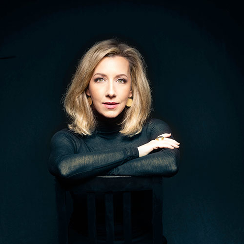 Darden Purcell wearing a long black gown with her arms folded