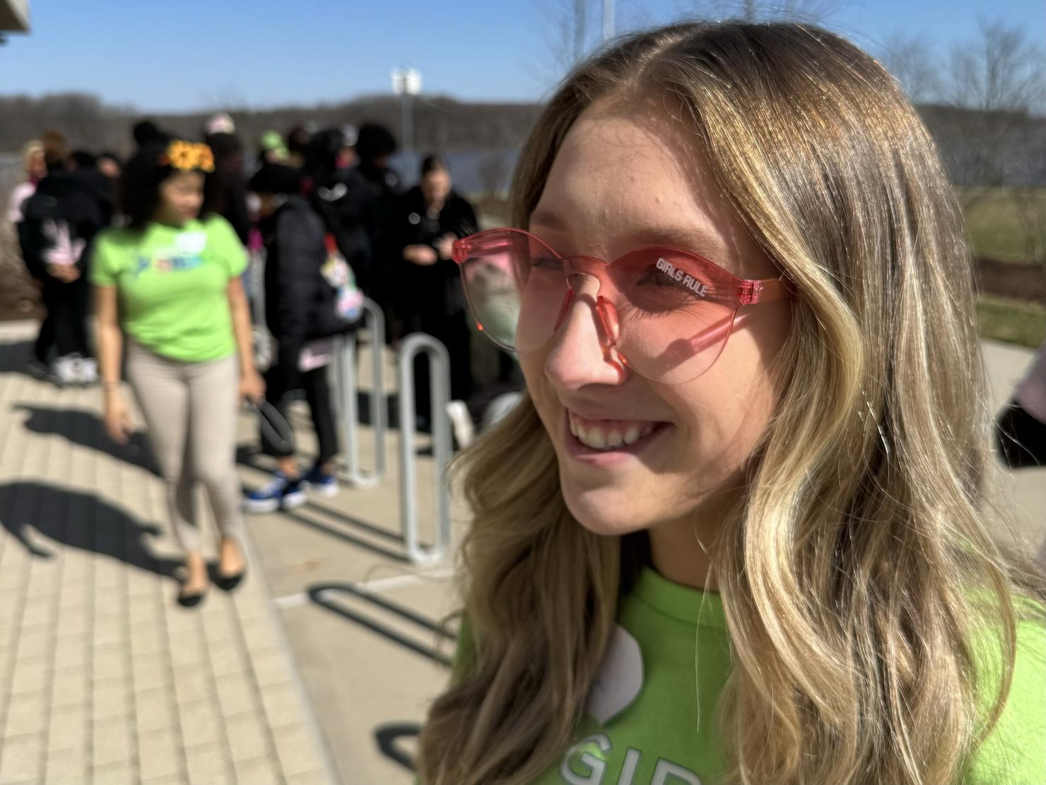 A staff member of Schneider Electric, one of the event sponsors, wears pink sunglasses that say "Girls Rule"