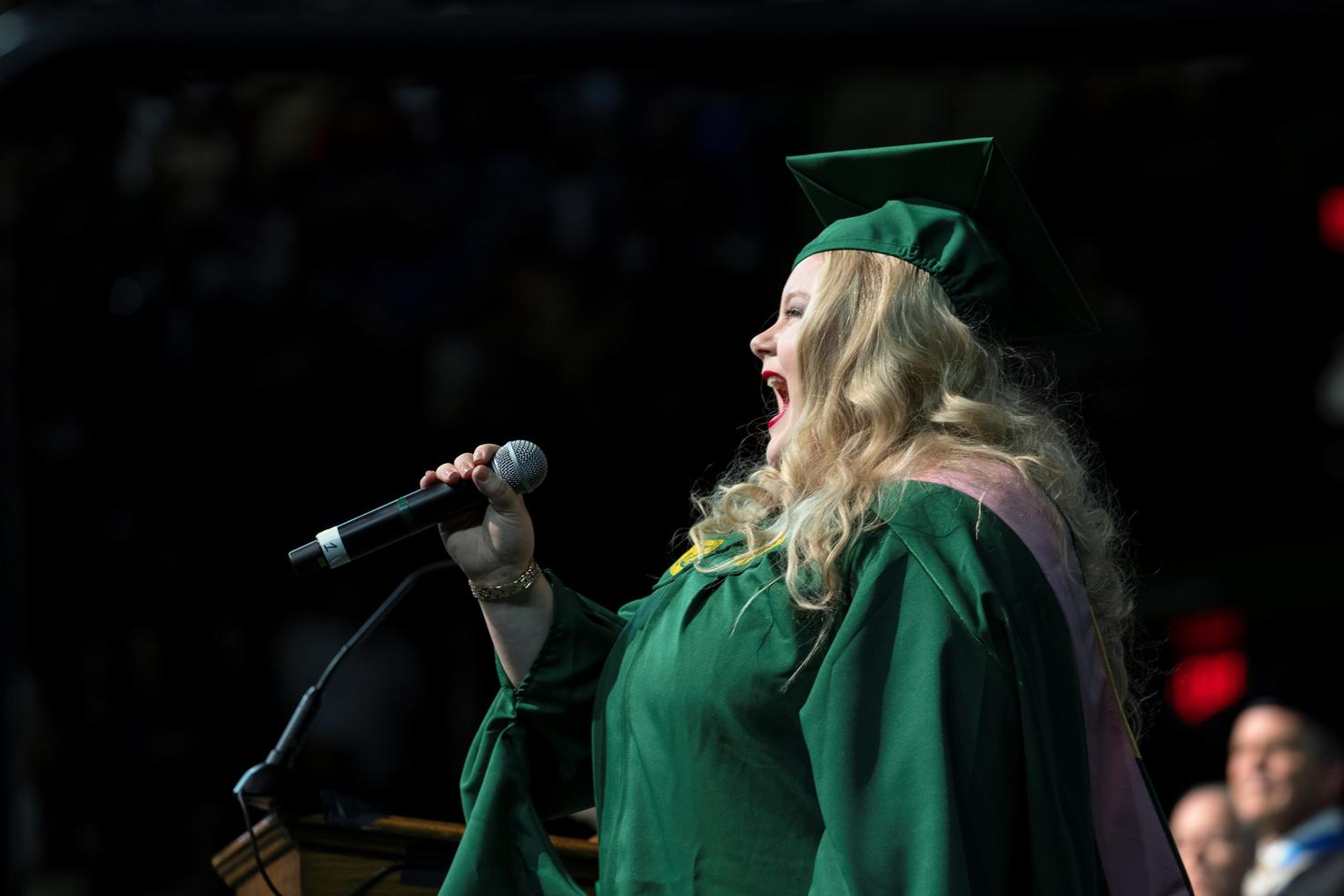 Student sings the National Anthem at Commencement