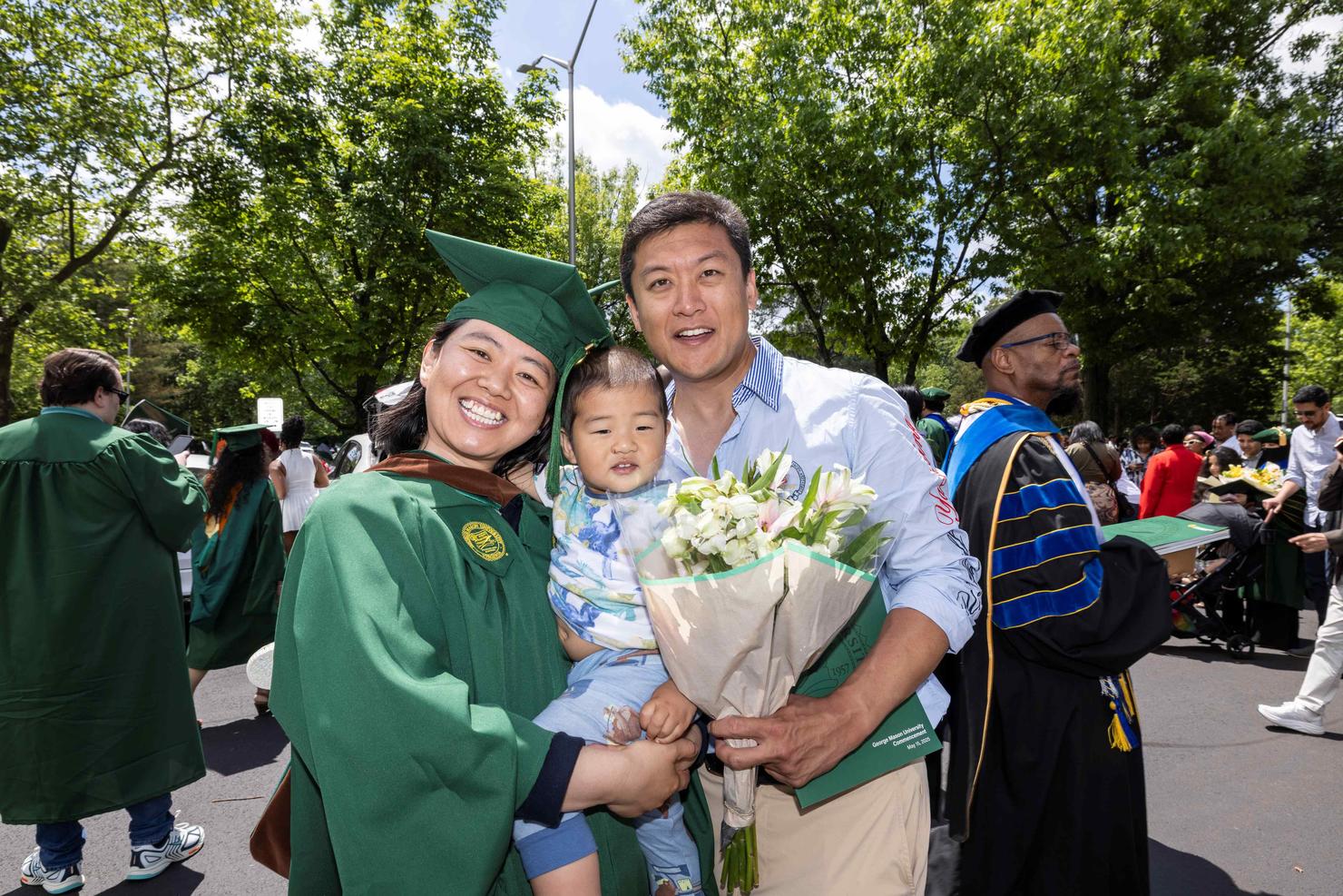Graduate smiles with her family outside EagleBank Arena