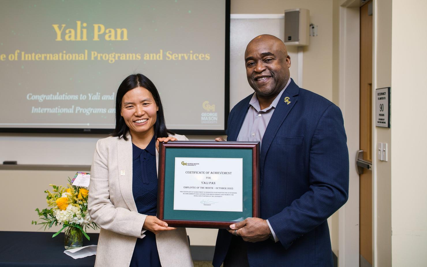 October Employee of the Month Yali Pan holds her certificate with President Gregory Washington at the ceremony