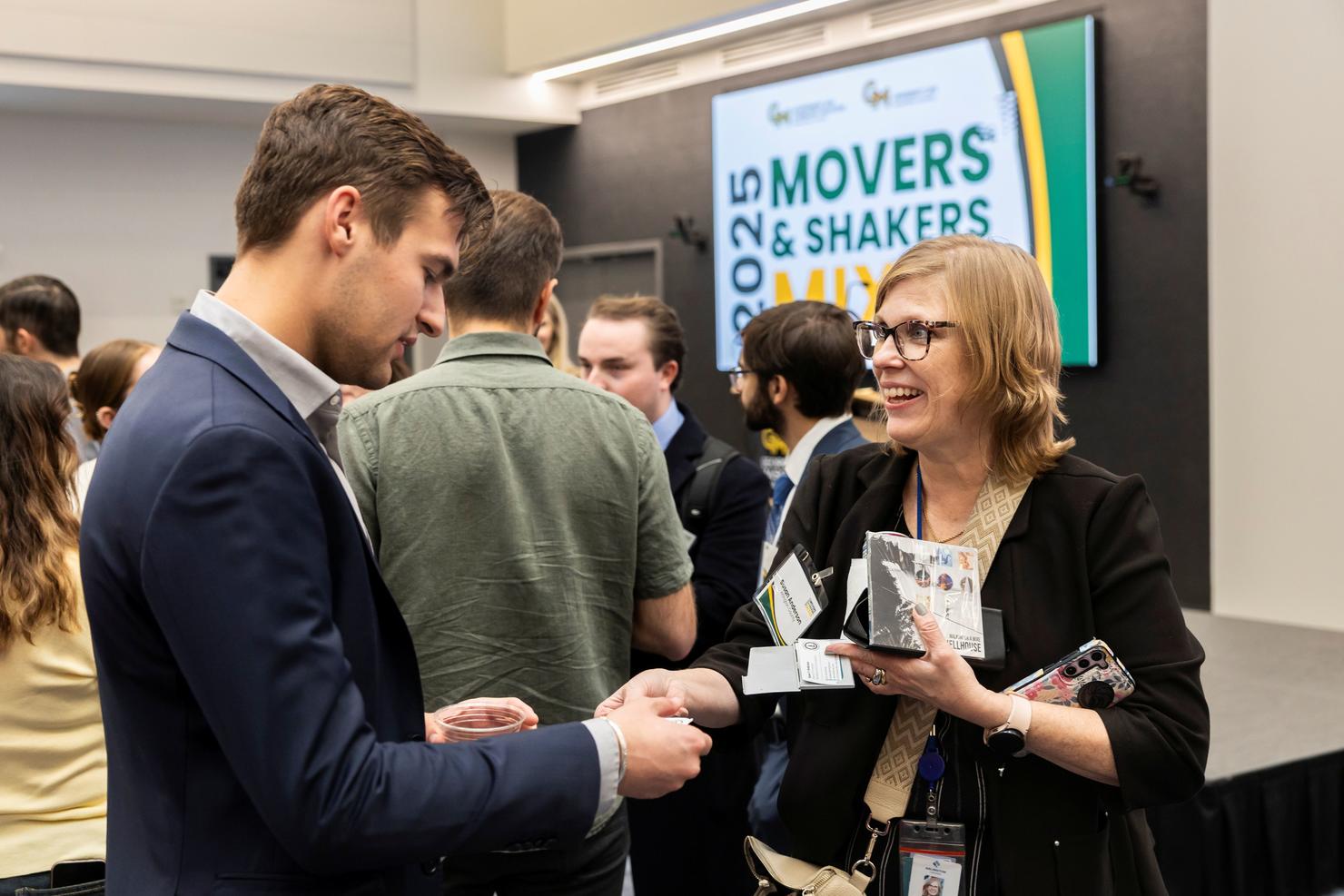 Two people speak to each other at the Movers and Shakers Mixer