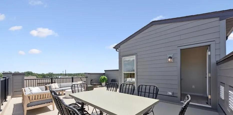 Exterior view of the rooftop terrace with space for a large dining table and sofa area