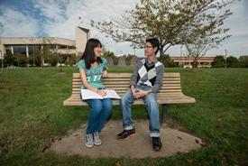 Students talking on a bench