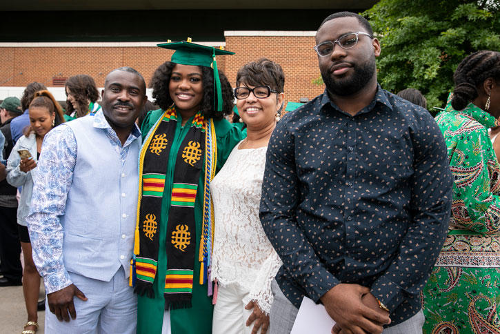 A Mason graduate with members of her family in front of EagleBank Arena on the Fairfax Campus