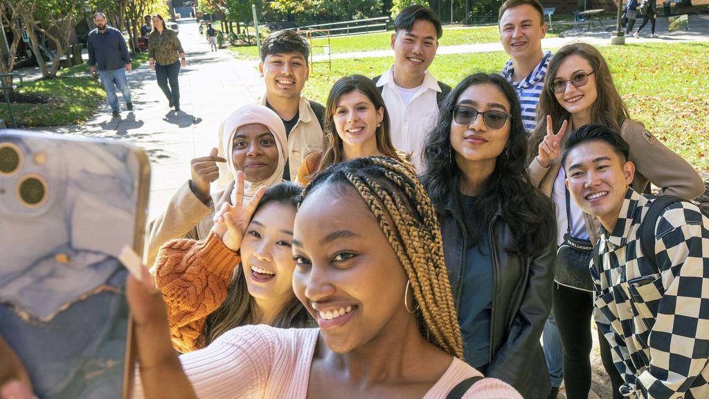 students taking a selfie outside on a sunny day. 