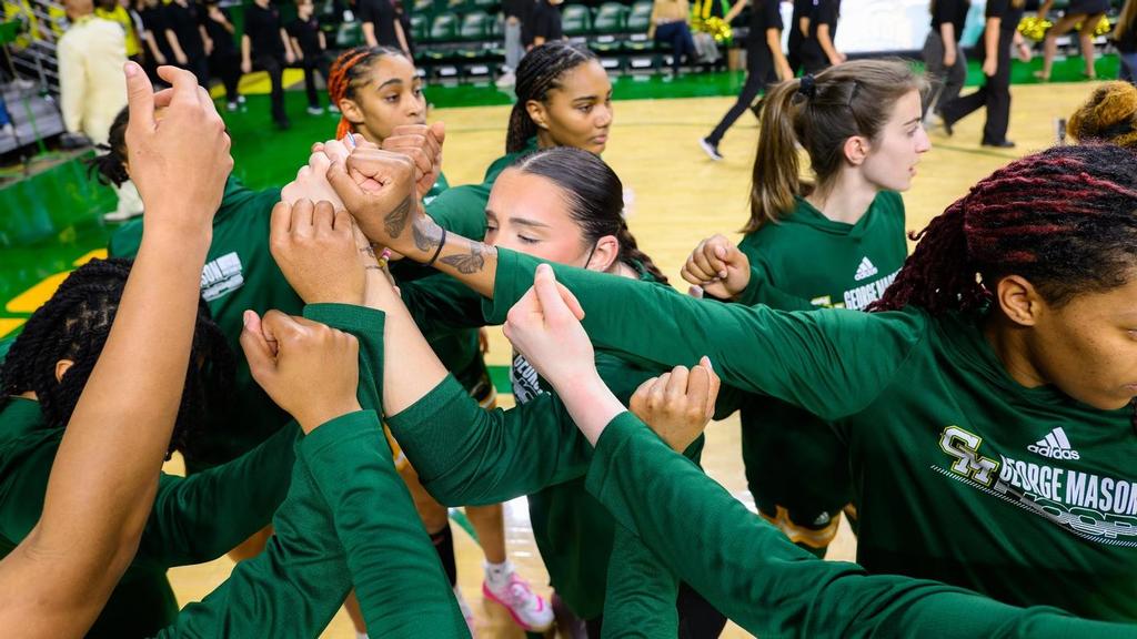 The George Mason women's basketball team returns to Fairfax this week to welcome St. Bonaventure to EagleBank Arena in the second game of the teams' home-and-home series. The players have there hands in the middle of a circle in a cheer