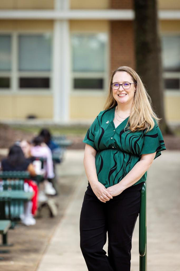 Rachel Spence leans against a bike rack on campus