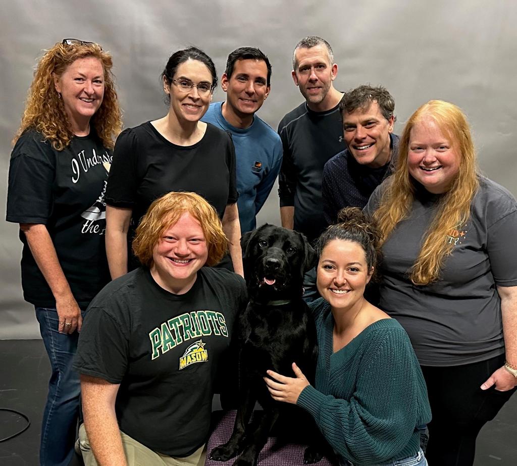 GMU-TV staff pose with Enrique the service-dog-in-training