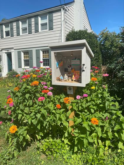 The Free Little Art Gallery is situated in a neighborhood and surrounded by beautiful flowers