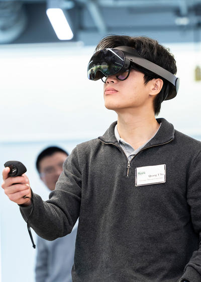 Quang Vo in a VR headset, his hand extended with a controller