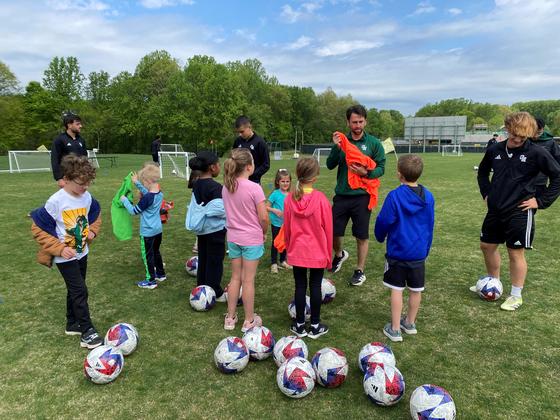 Junior Patriots practice soccer with members of the Mason men's soccer team