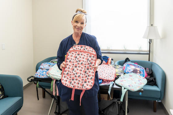 Amy Joyner with backpacks that were donated to the children at the clinic. Photo by Shayla Brown