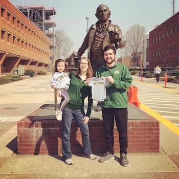 Bobby, Bridget, and their daughter in front of the George Mason statue. Photo provided.