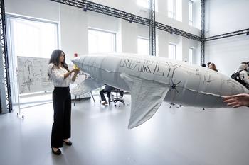 Andrea Dortch is working with Narly, a lighter-than-air vehicle shaped like a shark, in the multistory aviary.